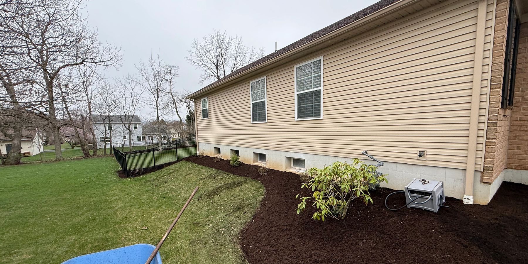 Fresh dark mulch along a home foundation